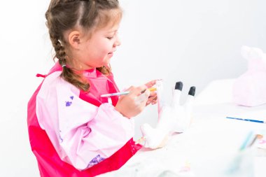 Küçük kız COVID-19 salgınında evde uzaktan öğrenim için sanat projesi üzerinde çalışıyor..