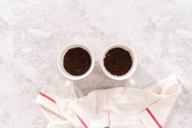 Düz yatıyordu. Beyaz bardaklarda çikolatalı kek hamuru pişmeye hazır..