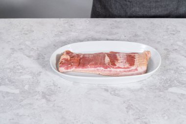 Pişmemiş pastırma şeritleri büyük beyaz bir tabakta..