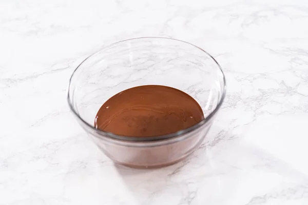 融化的巧克力在一个玻璃搅拌碗里 准备覆满巧克力的草莓 — 图库照片