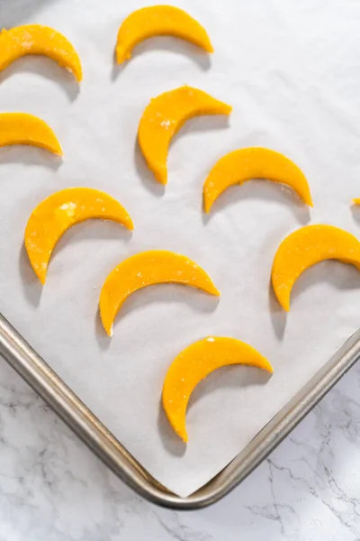 Lemon wedge cookies with lemon glaze. Rolling cookie dough with an adjustable rolling pin and cutting out cookies with cookie cutters to bake lemon wedge cookies with lemon glaze.