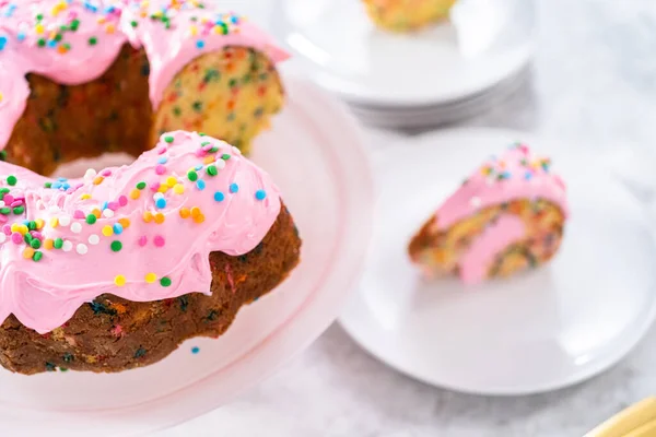 上にピンクのバタークリームのフロストとバタークリームが充填されたスライスされたFunetttiバントケーキ内側 — ストック写真