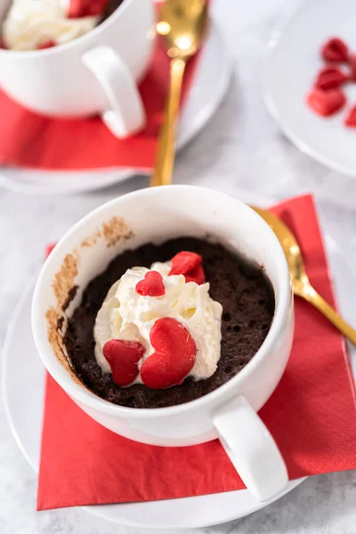 ホイップクリームとチョコレートの心と唇で装飾されたチョコレートマグカップケーキ — ストック写真