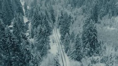 Rüzgarlı bir yol köyünün, dağların ortasından geçen kış görüntüsü.