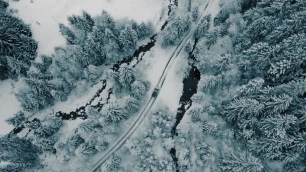 Winter-Luftaufnahmen von einem gekrümmten, windigen Straßendorf, das sich durch die Berglandschaft schneidet — Stockvideo