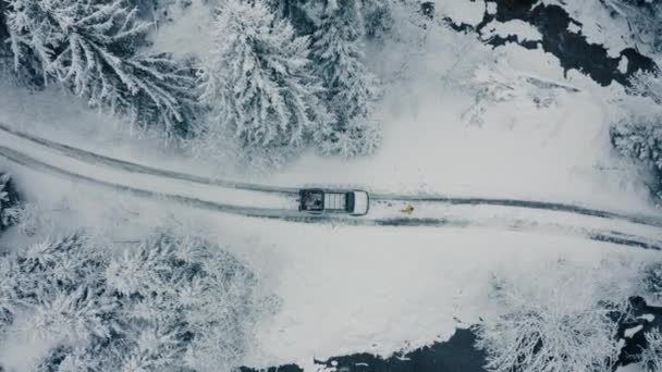 Imágenes aéreas de invierno de un pueblo sinuoso y curvo que atraviesa el paisaje montañoso — Vídeos de Stock