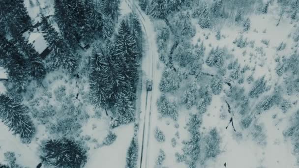 Inverno imagens aéreas de uma aldeia curva estrada ventosa cortando através da paisagem montanhas — Vídeo de Stock