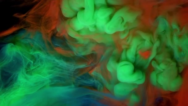 Yukarıdan renkli gökkuşağı boya damlaları suya karışıyor. yeşil kırmızı mavi boya rengi — Stok video