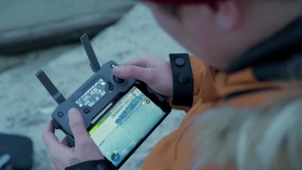 The guy controls the drones. remote control of the drone in hands is connection process Flight over the winter forest — Stok video