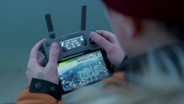 Парень управляет беспилотниками. дистанционное управление дроном в руках процесс соединения Полет над зимним лесом — стоковое видео