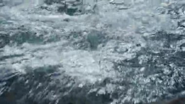 Küçük bir dağ nehrinde akan temiz suya yaklaş.