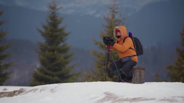 Fotograf turystyki zimowej. robić zdjęcia w zimowym lesie. — Wideo stockowe