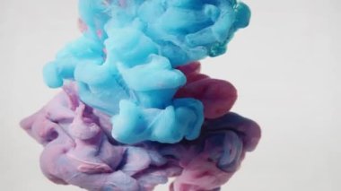 Suya yayılan mavi pembe simli mürekkep. Soyut beyaz arkaplan