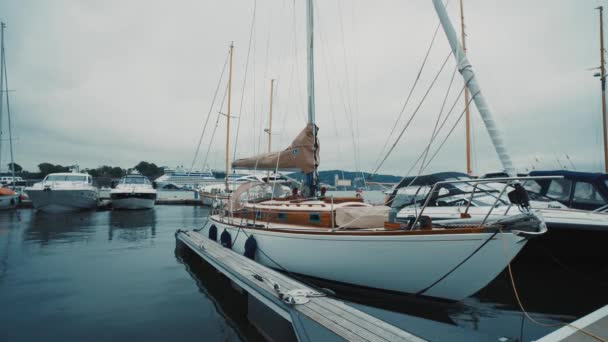 青い帆船は日没時にヨットマリーナの桟橋に係留された カラフルな雲 水の反射 セーリング レクリエーションのテーマ サウス ノルウェー村 — ストック動画