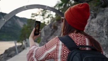 Nehir kenarında yürüyüş yapan güzel bir turist kız selfie çeker, telefonda kendi fotoğrafını çeker..