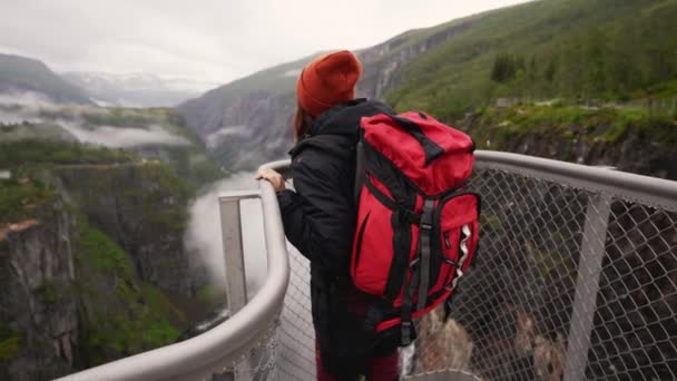 一个女人站在悬崖边上 站在漩涡中的瀑布边 感觉完全自由了 — 图库视频影像