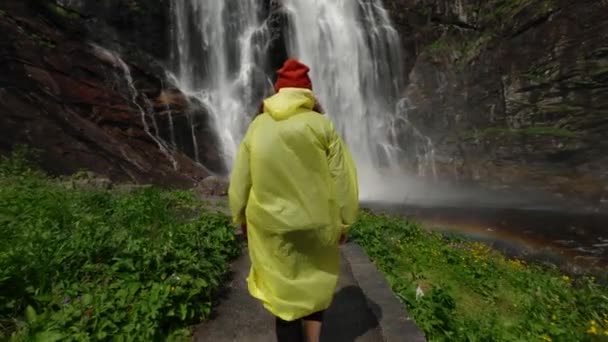 비옷을 등산을 소녀는 고지대에 폭포로 걸어가서 생명을 즐긴다 여행하고 모험을 — 비디오