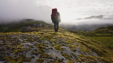 Sisli dağlarda erkek kaşiflere tırmanmak zor. Dağ uçurumundan manzara yok ama sis var..