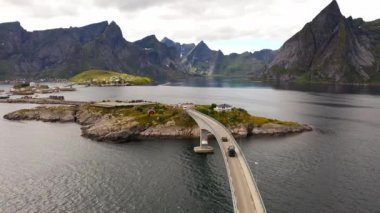 Güneşli bir günde köprüden geçen araba, Reine, Lofoten, Norveç hava manzaralı yaz günü