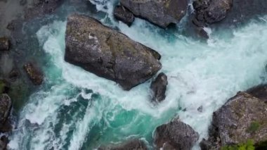 Dağ zümrüdü nehri, taştan kıyı ve ormanın güçlü akıntısı, kristal berrak dağ nehri kıvrımlarıyla. Güneşli yaz gününde tepeden aşağıya hava aracı görüntüsü