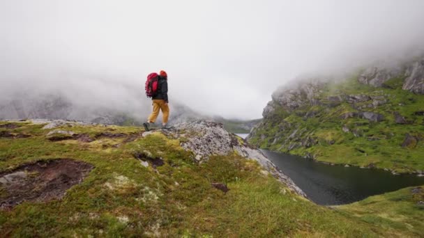 Egy Piros Hátizsákos Turista Sétál Ködben Egy Sziklán Norway Hegyeiben — Stock videók