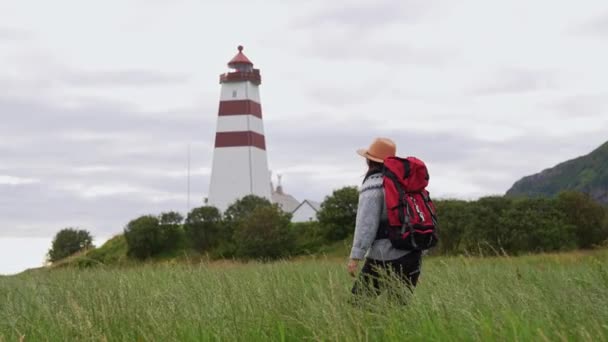 ノルウェーの灯台の海の風景を楽しむ旅行者の女の子旅行ライフスタイルのコンセプトアドベンチャースカンディナヴィアの休暇屋外 — ストック動画