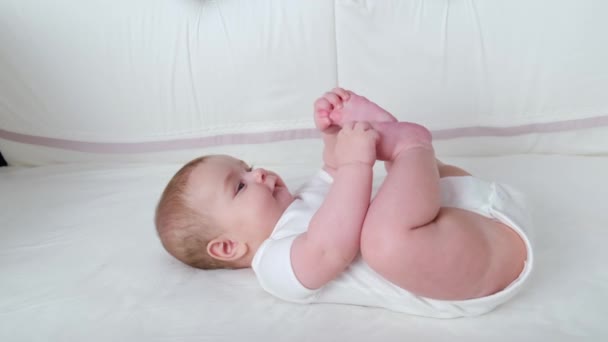 Βρεφικό Μωρό Ξαπλωμένο Ένα Κρεβάτι Και Παίζοντας Πόδια — Αρχείο Βίντεο