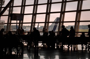 MOSCOW, RUSSIA - 08 22 2020: Moskova 'daki Vnukovo Uluslararası Havalimanı' nın camsı duvarının önündeki yolcu siluetleri