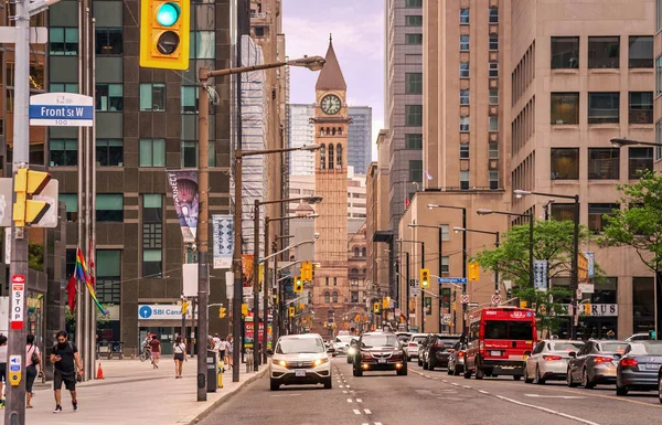 TORONTO, CANADA - 06 05 2021: Toronto şehir merkezindeki körfez caddesi boyunca uzanan yaz manzarası, 1899 tarihli Richardsonian Romanesk şehir binası, saat kulesi ve arka planında heykelciklerle