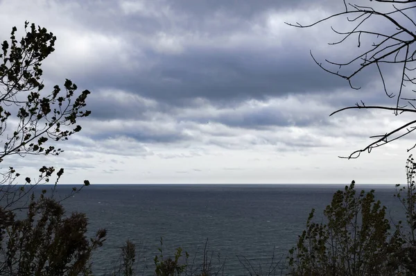 鉛の暗い湖の上の悲観的な曇りの秋の空は地平線にその水を伸ばし — ストック写真
