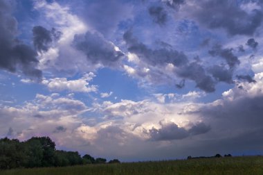 Renkli sonbahar akşamı manzarası dramatik bulutlu günbatımı gökyüzü tarlaların üzerinde ekinlerle birlikte.