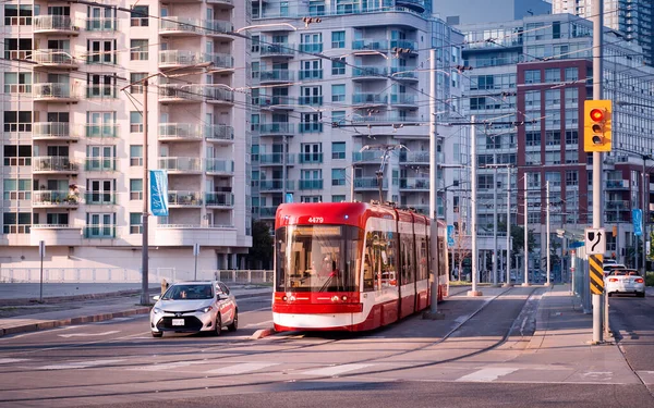Toronto, Canada - 08 03 2018: A new Bombardier-made TTC streetcar in front of residential high-rise buildings on Queens Quay West street in downtown Toronto. Toronto Transit Commission is a public transport agency that operates bus, streetcar and sub