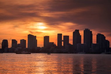 Summer sunset view from Toronto Islands across the Inner Harbour of the Lake Ontario on Downtown Toronto skyline with skyscrapers under a magnificent sky