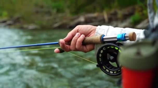El pescador de mosca captura peces. Carrete de pesca con agua de río — Vídeos de Stock