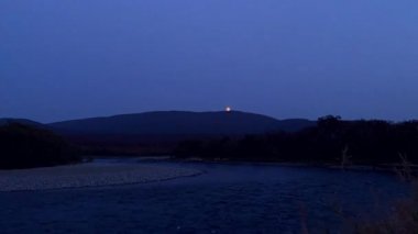 The moon rising over the mountains and the river. Volcanoes of Kamchatka.