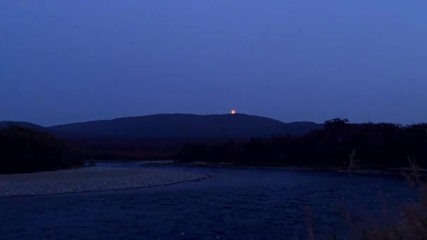 The moon rising over the mountains and the river. Volcanoes of Kamchatka. — Vídeos de Stock