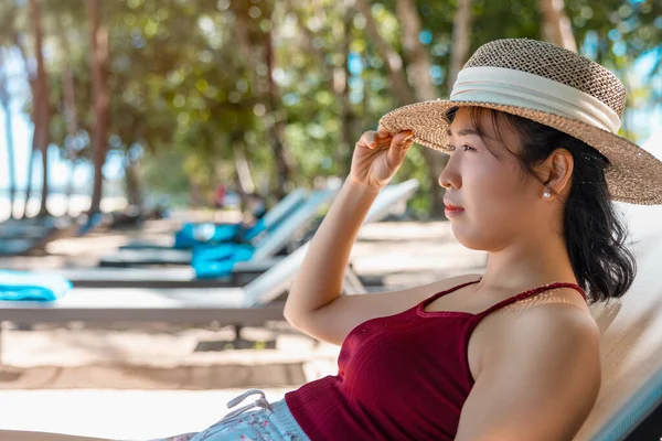 Kırmızı Mayo Hasır Şapka Giyen Asyalı Manken Deniz Kenarında Güneşlenir — Stok fotoğraf