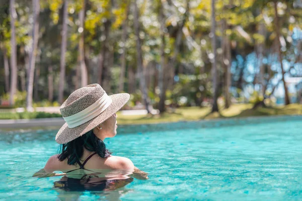 Kırmızı Mayo Hasır Şapkalı Mutlu Asyalı Kadın Yüzme Havuzunda Dinleniyor — Stok fotoğraf