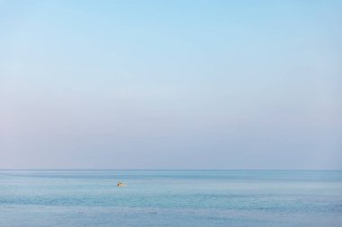 Gökyüzü ve mavi denizle rahatlatıcı deniz manzarası.