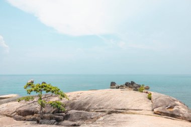 Ön planda kayalar, arka planda gökyüzü olan deniz manzarası. Terapötik doğal manzara bir rahatlama hissi verir. Koh Samui, Surat Thani Eyaleti, Tayland.