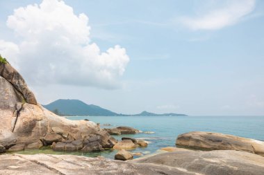 Ön planda kayalar, arka planda gökyüzü olan deniz manzarası. Terapötik doğal manzara bir rahatlama hissi verir. Koh Samui, Surat Thani Eyaleti, Tayland.