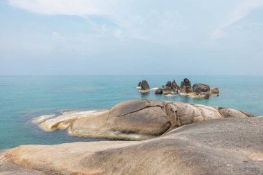 Ön planda kayalar, arka planda gökyüzü olan deniz manzarası. Terapötik doğal manzara bir rahatlama hissi verir. Koh Samui, Surat Thani Eyaleti, Tayland.