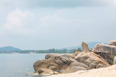 Ön planda kayalar, arka planda gökyüzü olan deniz manzarası. Terapötik doğal manzara bir rahatlama hissi verir. Koh Samui, Surat Thani Eyaleti, Tayland.