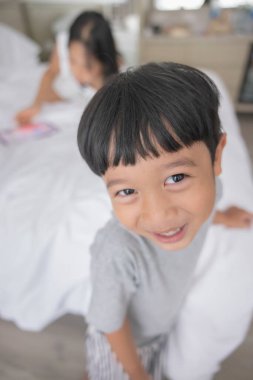 Close-up of smiling little asian boy look in camera wear grey clothes. Portrait of happy cute boy.