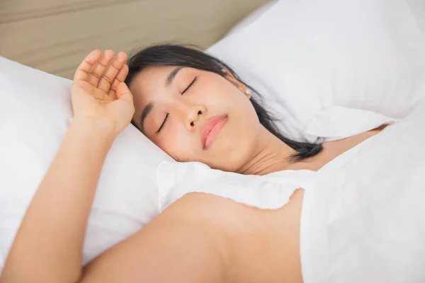 Young asian woman sleeping in bed at bedroom. she is lying on side and relax with eyes closed.