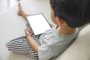 Yakın plan mutlu Asyalı çocuk el ele tutuşup beyaz arka planda izole edilmiş dijital tablet beyaz ekranla parmak dokunuşu yapıyor. Teknoloji kavramı, bağlantı, iletişim, sosyal.