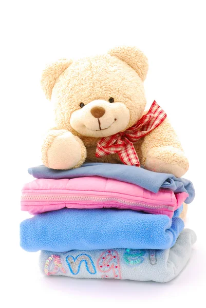 Teddy bear stack of kids clothes — Stock Photo, Image