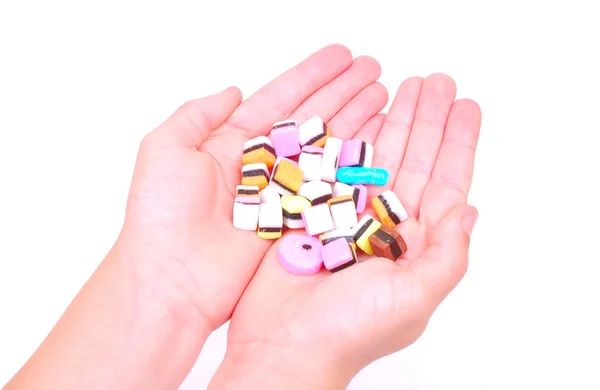 Colorful candies in hands — Stock Photo, Image