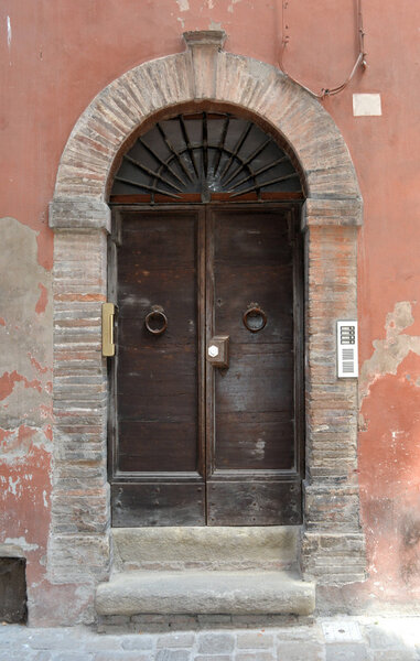 An medieval wooden Italian door in the city.
