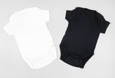 İki boş bebek giysisi, yeni doğmuş bir vücut modeli.